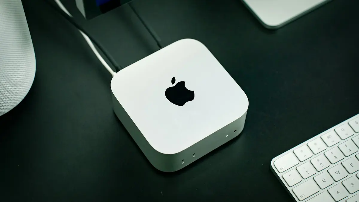 Mac mini sur un bureau, avec clavier et écran
